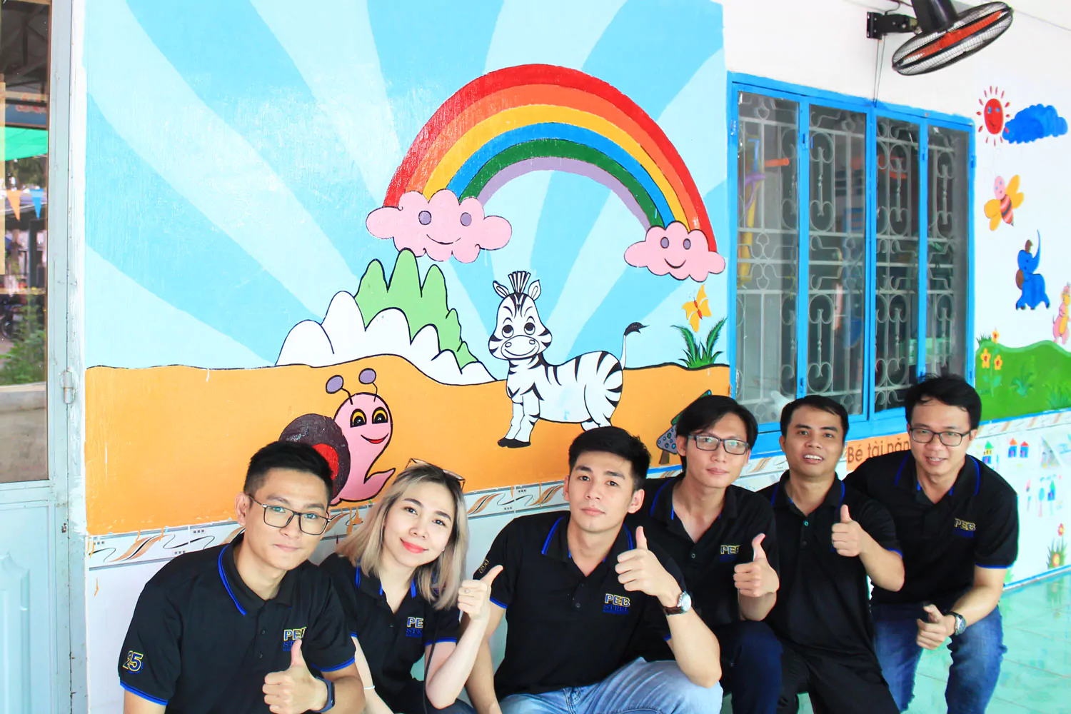 Nhân viên PEB đã giúp các giáo viên vẽ những bức tranh đầy màu sắc lên tường lớp học.