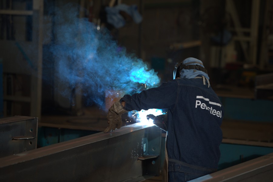 A worker does the steel fabrication process in the Pebsteel pre-engineered steel factory.