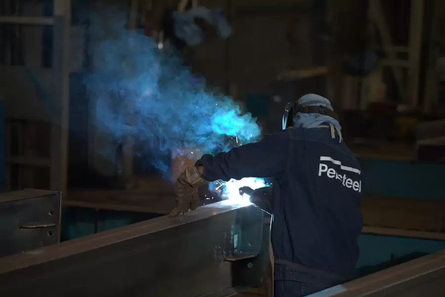 A worker does the steel fabrication process in the Pebsteel pre-engineered steel factory.